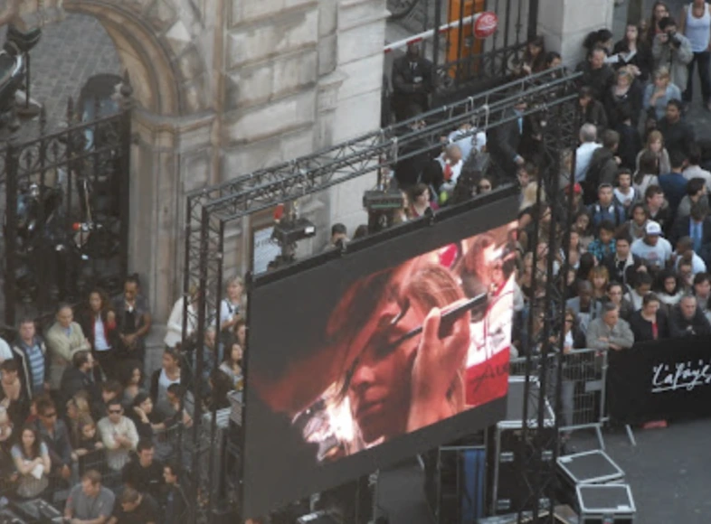 Écran géant diffusant le Grand Défilé devant les spectateurs