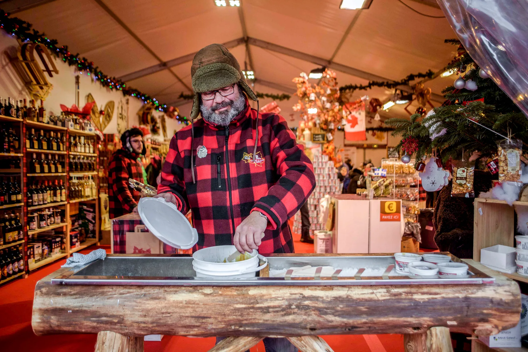 Artisan devant son stand au village de Noël de La Défense